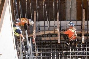 electricians installing conduit at construction site